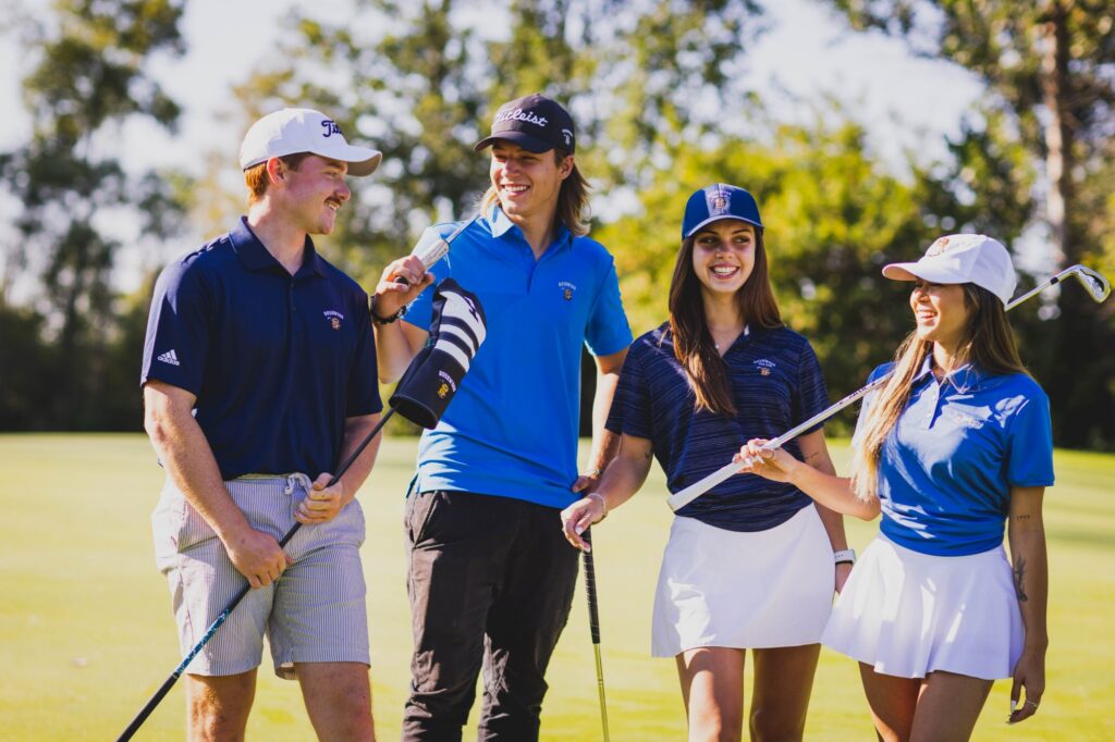 Four friends in Bushwood polos laughing together on the golf course